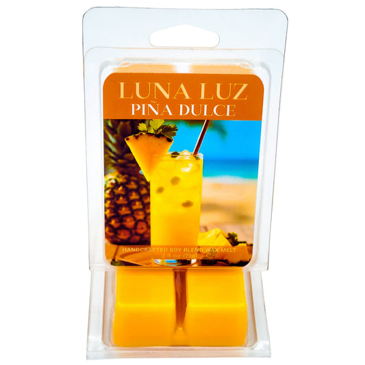 Luna Luz Pina Dulce wax melt clamshell with pineapple cocktail on beachy setting. Wax melt set on a white background.